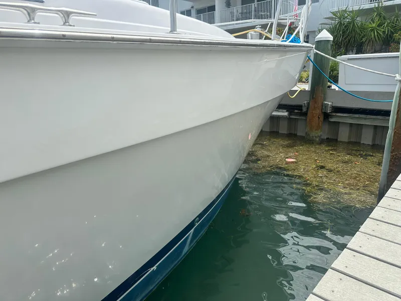 Slide: The Image of 1999 Mainship 430 Trawler docked, side view showing hull and water reflection. - 21