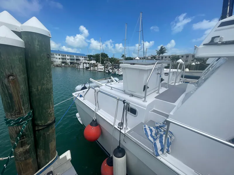 Slide: The Image of 1999 Mainship 430 Trawler docked at marina with clear blue sky. - 28