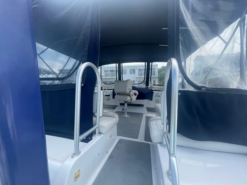 Slide: The Image of 1999 Mainship 430 Trawler interior with seating and helm, featuring blue and white upholstery. - 29