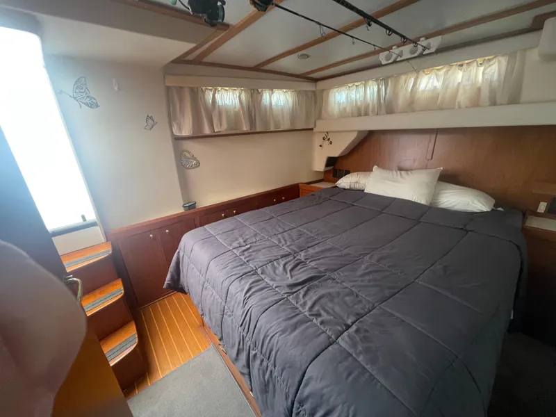 Slide: The Image of Cozy bedroom in 1999 Mainship 430 Trawler with wood accents and natural light. - 34
