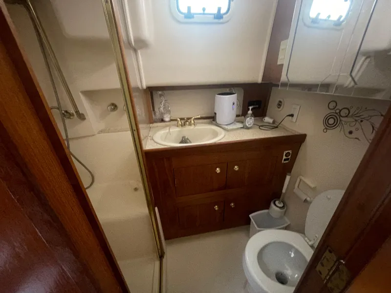 Slide: The Image of Bathroom of 1999 Mainship 430 Trawler with sink, toilet, and shower. - 36