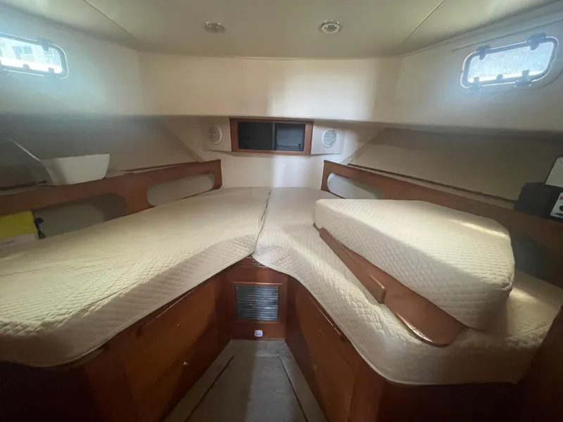 Slide: The Image of 1999 Mainship 430 Trawler cabin interior with twin beds and wooden furnishings. - 37