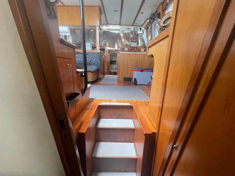 Slide: The Image of Interior view of 1999 Mainship 430 Trawler, featuring wooden stairs and cozy cabin space. - 41