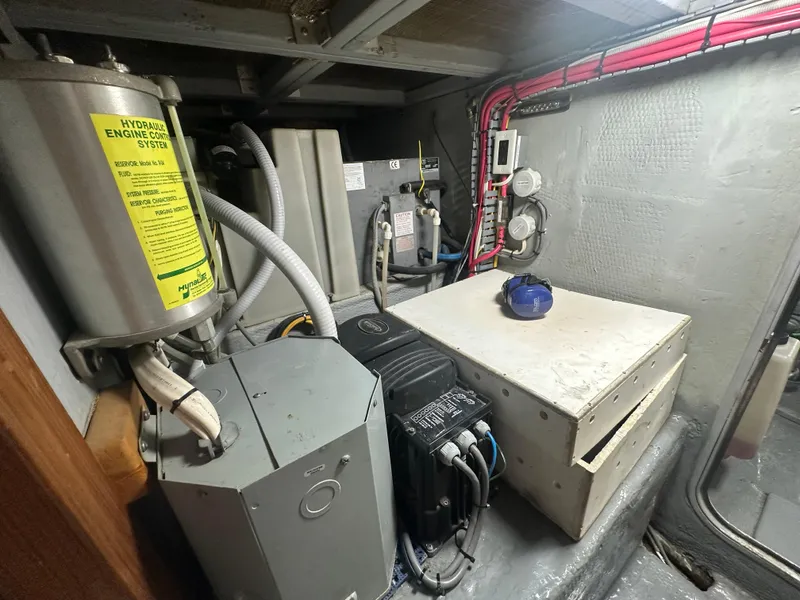 Slide: The Image of Engine room of 1999 Mainship 430 Trawler with hydraulic system and electrical components. - 49