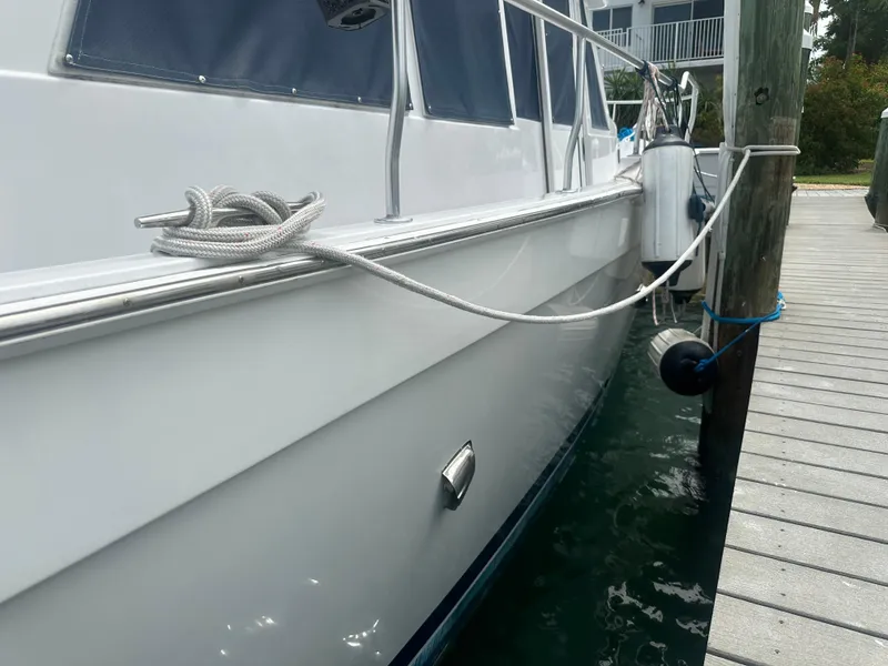 Slide: The Image of 1999 Mainship 430 Trawler docked, side view with rope and fender. - 6