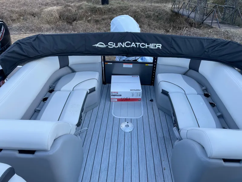Slide: The Image of 2025 SunCatcher Select 322RC pontoon boat interior with seating and protective cover. - 11