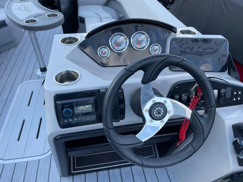 Slide: The Image of 2025 SunCatcher Select 322RC boat dashboard with steering wheel and gauges. - 5