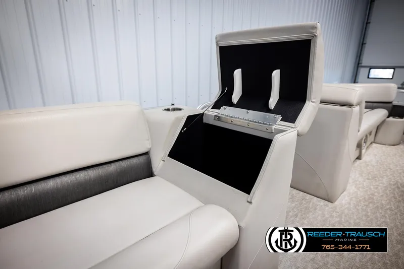 Slide: The Image of 2021 Avalon VLS QL boat interior with open storage compartment, beige seating, and logo. - 21