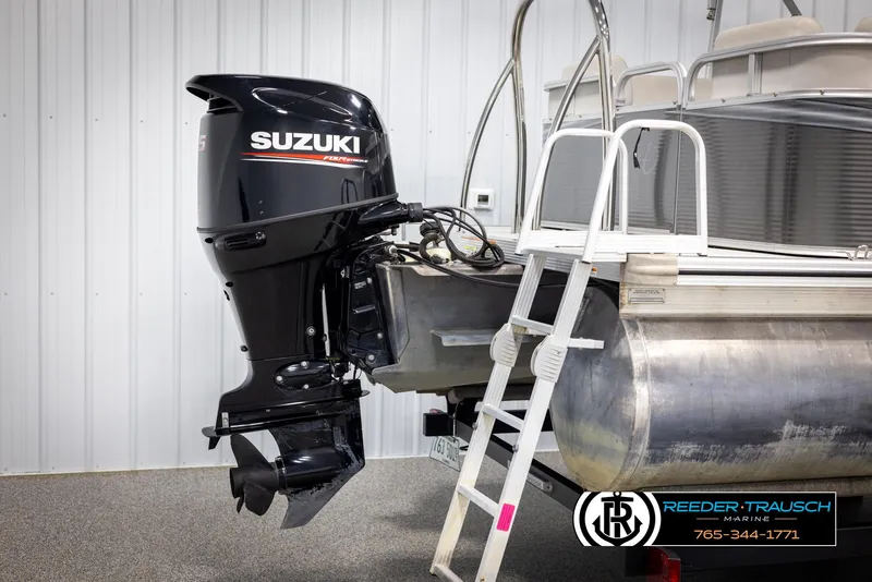 Slide: The Image of 2021 Avalon VLS QL pontoon with Suzuki outboard motor and ladder, displayed indoors. - 39