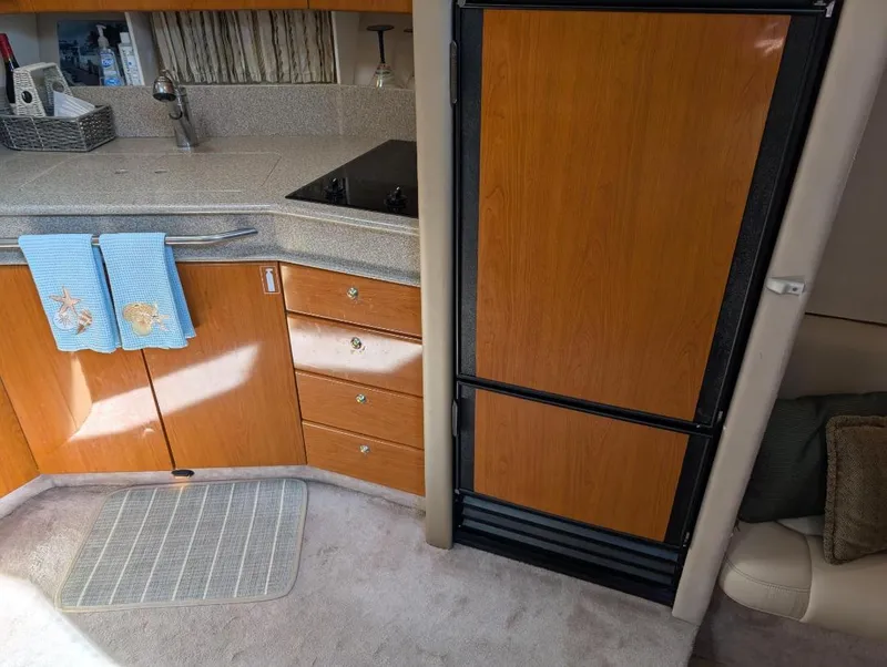 Slide: The Image of 2002 Formula 41 PC yacht kitchen with wooden cabinets and refrigerator. - 25