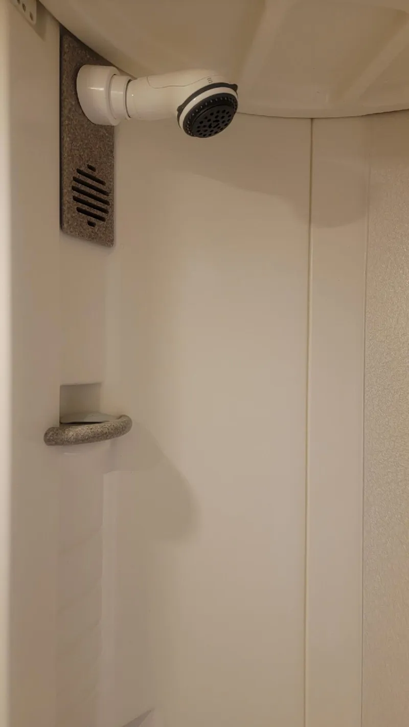 Slide: The Image of Shower area in 2002 Formula 41 PC boat, featuring a white showerhead and grab bar. - 32