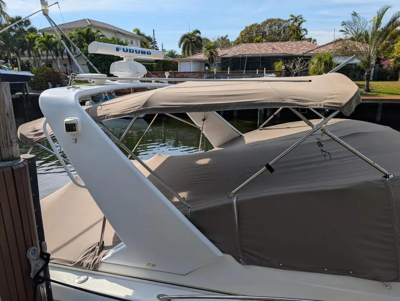 Slide: The Image of 2002 Formula 41 PC boat with beige canopy docked near waterfront homes. - 4