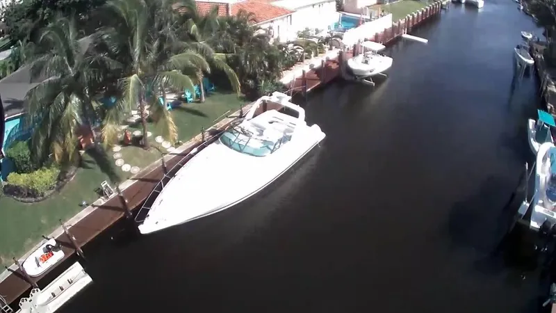 Slide: The Image of 2002 Formula 41 PC yacht docked in a scenic canal with palm trees. - 9