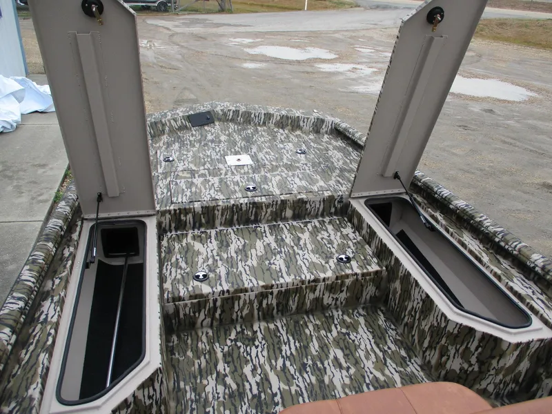 Slide: The Image of 2025 Avid 22 RECON CC boat interior with camo design and open storage compartments. - 11