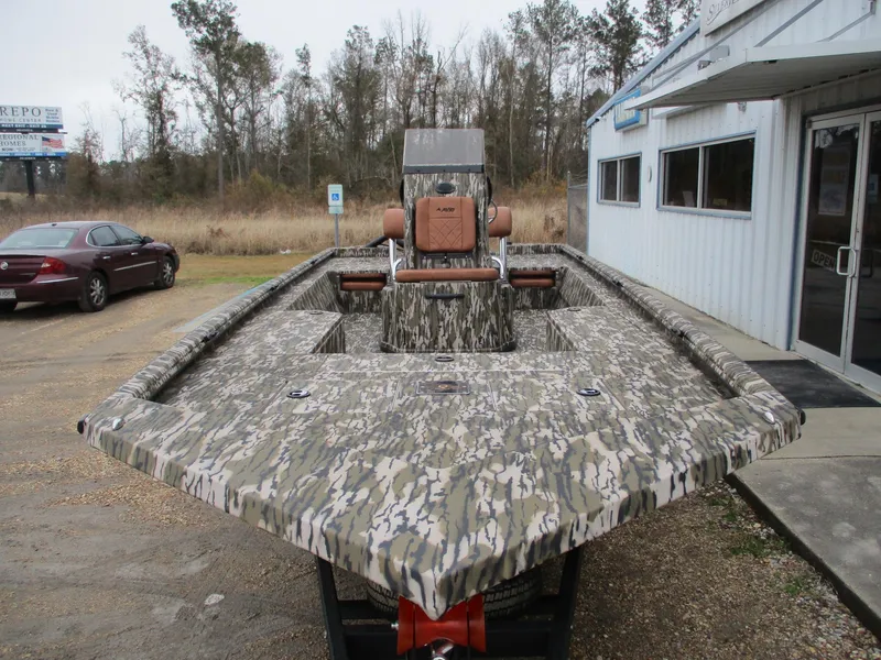 Slide: The Image of 2025 Avid 22 RECON CC boat with camouflage design, parked outside a building. - 12