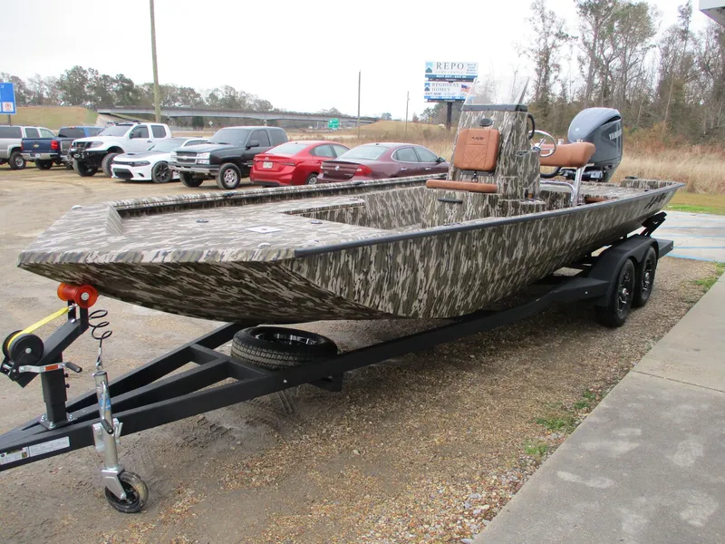 Slide: The Image of 2025 Avid 22 RECON CC boat on trailer, camo design, parked outdoors. - 2