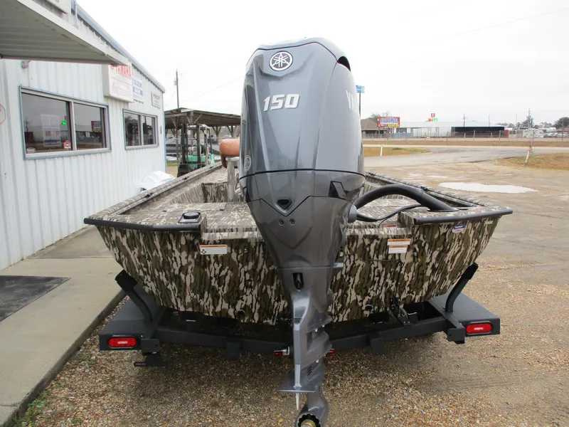 Slide: The Image of 2025 Avid 22 RECON CC boat with Yamaha 150 outboard motor, camo design, parked outside. - 5