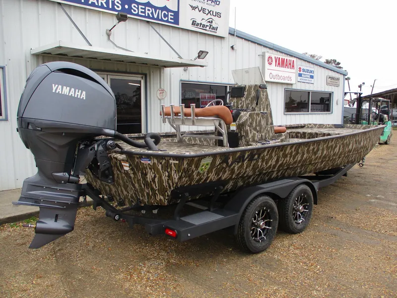 Slide: The Image of 2025 Avid 22 RECON CC boat with Yamaha outboard motor, parked outside a service shop. - 6