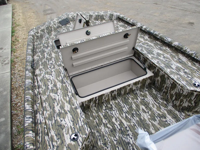Slide: The Image of 2025 Avid 22 RECON CC boat with open storage compartments, featuring a camouflage design. - 7