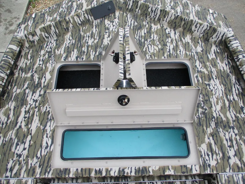 Slide: The Image of 2025 Avid 22 RECON CC boat interior with camo pattern and storage compartments. - 9