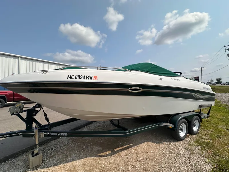 Slide: The Image of 1999 Four Winns 240 Horizon boat on trailer, parked outdoors under a cloudy sky. - 1