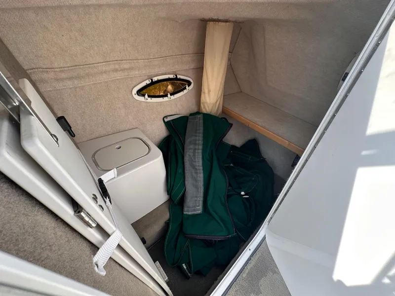 Slide: The Image of Interior cabin of 1999 Four Winns 240 Horizon boat with storage and green cover. - 11
