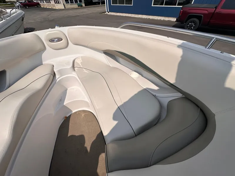 Slide: The Image of Interior seating of a 1999 Four Winns 240 Horizon boat, featuring beige upholstery. - 12