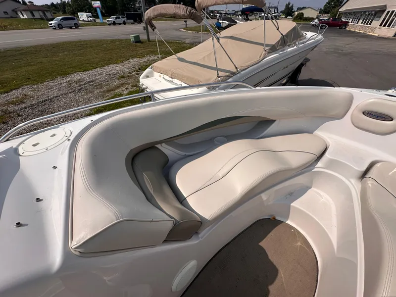 Slide: The Image of 1999 Four Winns 240 Horizon boat interior with white seating and outdoor view. - 13