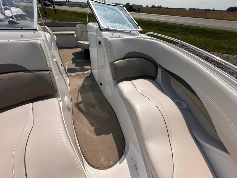 Slide: The Image of 1999 Four Winns 240 Horizon boat interior with white seating and open deck layout. - 15