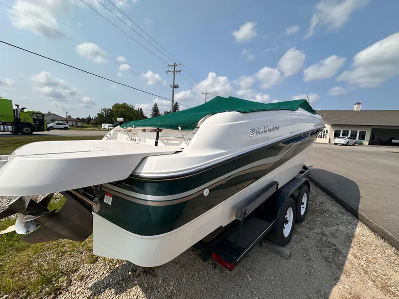 Slide: The Image of 1999 Four Winns 240 Horizon boat on trailer, green cover, parked outdoors. - 3