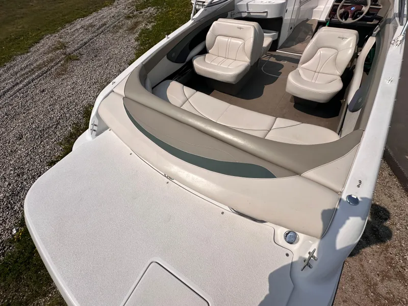 Slide: The Image of 1999 Four Winns 240 Horizon boat interior with white seating and open deck. - 4