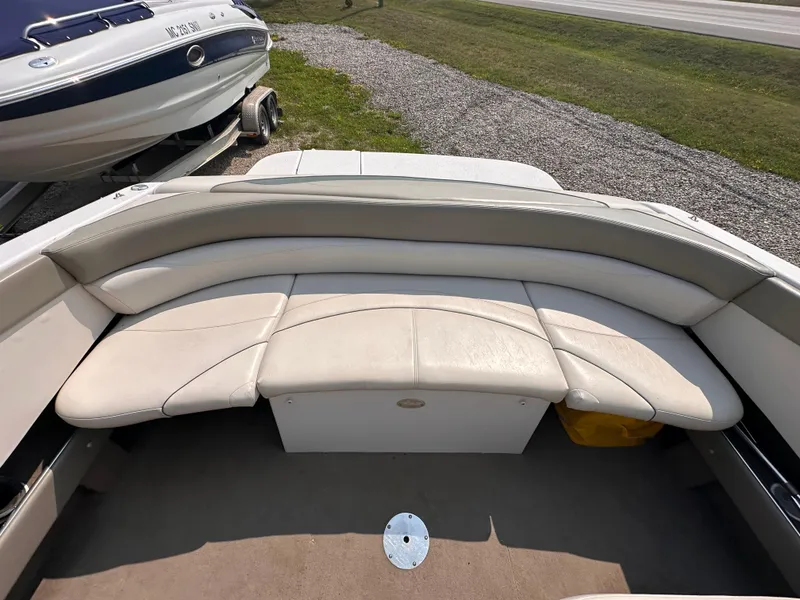 Slide: The Image of 1999 Four Winns 240 Horizon boat interior with beige seating and carpeted floor. - 6
