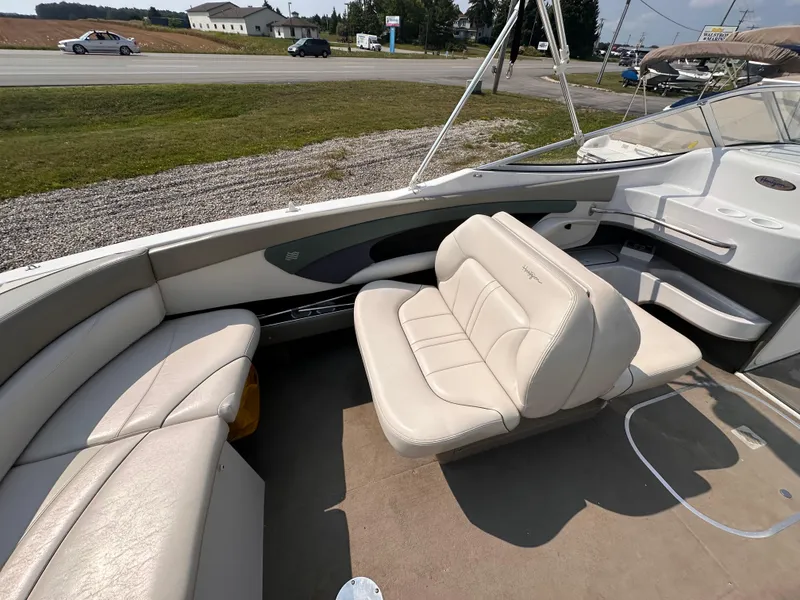Slide: The Image of 1999 Four Winns 240 Horizon boat interior with beige seating and open deck view. - 8