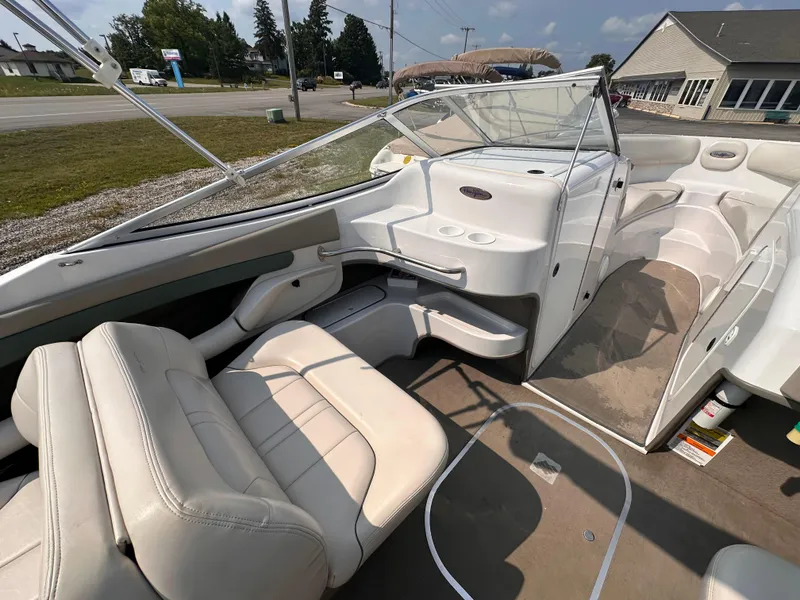 Slide: The Image of 1999 Four Winns 240 Horizon boat interior with beige seating and open deck layout. - 9