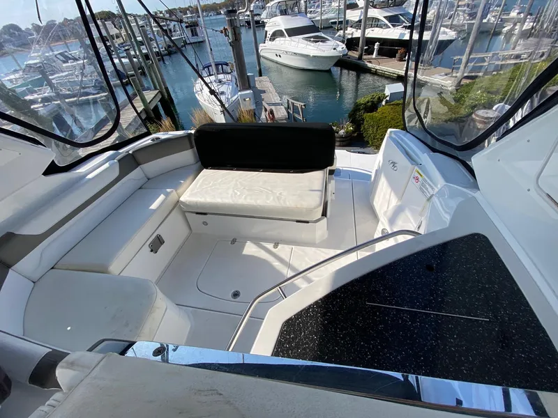 Slide: The Image of 2015 Monterey 335 Sport Yacht interior with marina view, featuring white seating and sleek design. - 10
