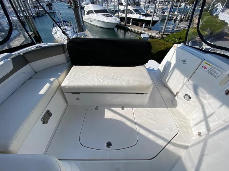 Slide: The Image of 2015 Monterey 335 Sport Yacht interior with white seating, docked at marina. - 11