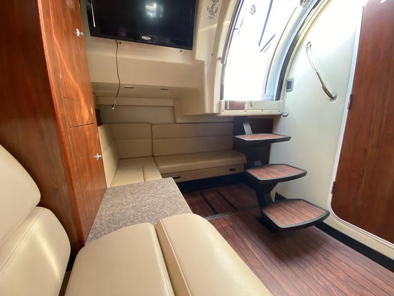 Slide: The Image of Interior of 2015 Monterey 335 Sport Yacht with wooden flooring and beige seating. - 19