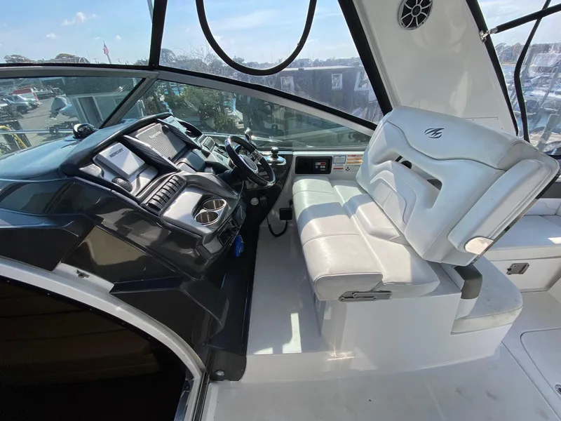 Slide: The Image of 2015 Monterey 335 Sport Yacht cockpit with modern controls and white seating. - 9