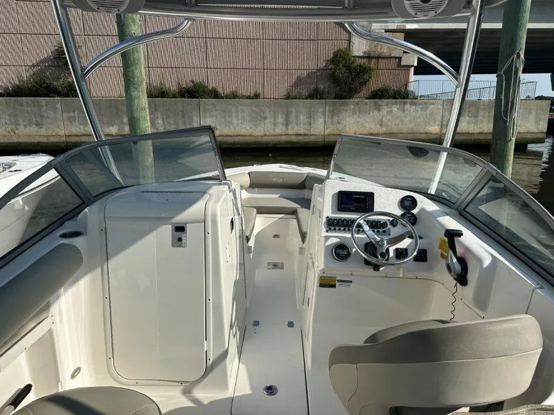 Slide: The Image of 2023 Key West 239 DFS boat interior with steering wheel and seating area. - 2