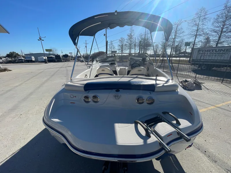 Slide: The Image of 2012 Tahoe Q4 SS boat with canopy, parked outdoors on a sunny day. - 3