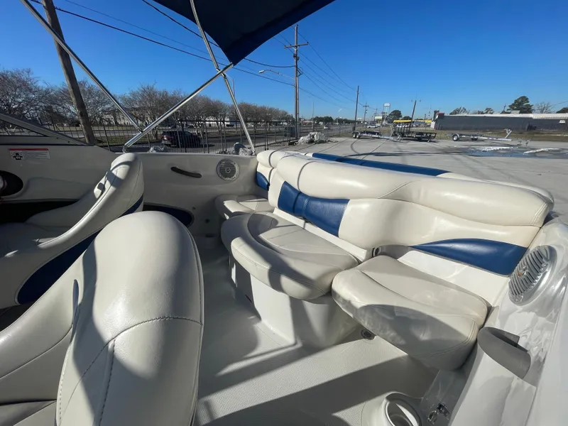 Slide: The Image of 2012 Tahoe Q4 SS boat interior with white and blue seating under a clear sky. - 5