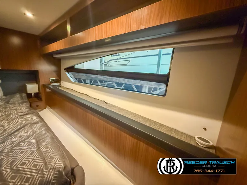 Slide: The Image of 2021 Four Winns Vista 355 Coupe OB interior cabin with modern wood finish and window view. - 19