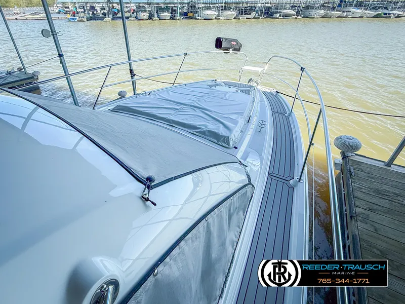 Slide: The Image of 2021 Four Winns Vista 355 Coupe OB docked, showcasing sleek design and spacious deck. - 2