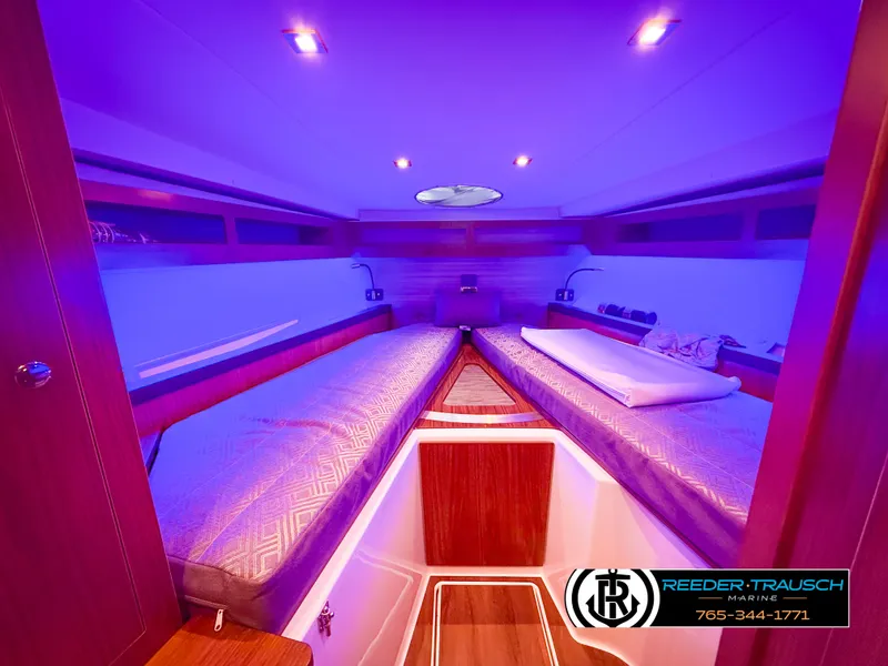 Slide: The Image of Interior of 2021 Four Winns Vista 355 Coupe OB with ambient lighting and twin beds. - 21