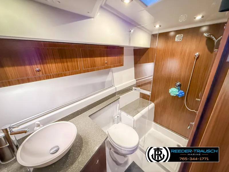 Slide: The Image of 2021 Four Winns Vista 355 Coupe OB bathroom with modern fixtures and wood accents. - 26