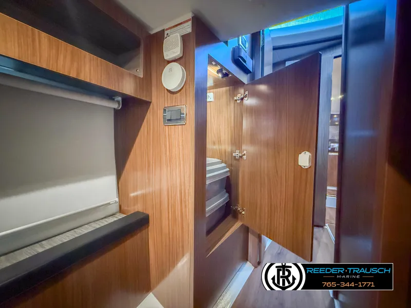 Slide: The Image of Interior of 2021 Four Winns Vista 355 Coupe OB, featuring wood cabinetry and modern design. - 28