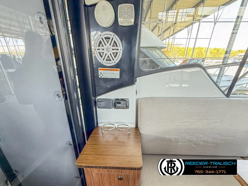 Slide: The Image of Interior of 2021 Four Winns Vista 355 Coupe OB with speaker and wooden table. - 8