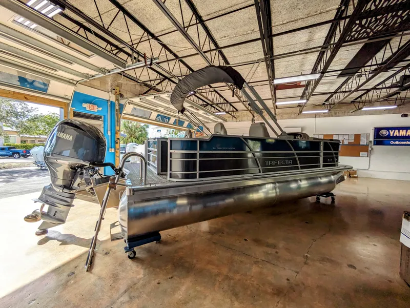 Slide: The Image of 2024 Trifecta 22TRFC LE 2.75 pontoon boat in a showroom with Yamaha outboard motor. - 11