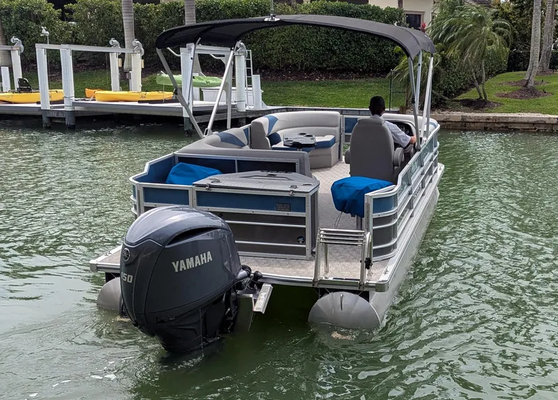 Slide: The Image of 2024 Trifecta 22TRFC LE 2.75 pontoon boat with Yamaha engine on a calm waterway. - 15