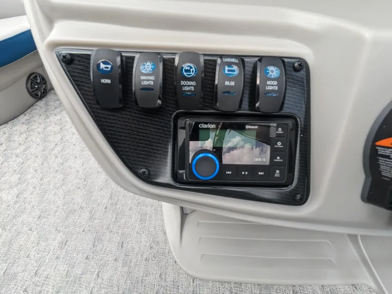 Slide: The Image of Control panel of 2024 Trifecta 22TRFC LE 2.75 boat with switches and Clarion audio system. - 19